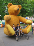 833594 Afbeelding van een rijwiel met een reusachtige teddybeer achterop, bij de start van 'La Caravane d'Utrecht' in ...